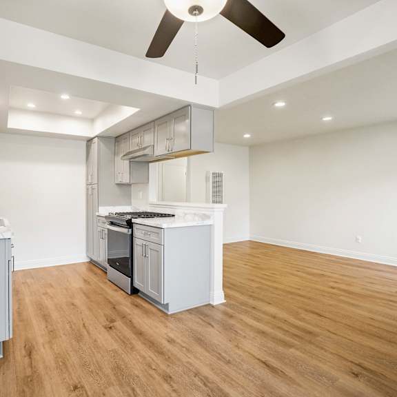 a kitchen with white cabinets and a wooden floor.