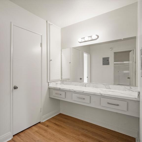 a white bathroom with a vanity and medicine cabinet.