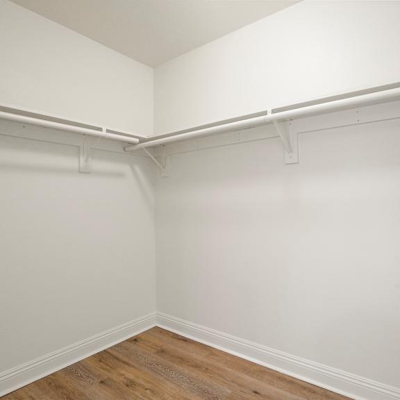 a white wall with a wooden floor and a door handle.