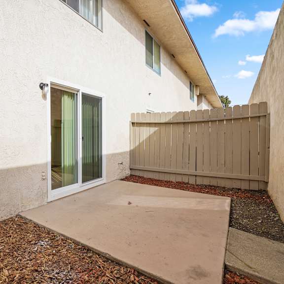 a white house with a brown fence and a glass door.