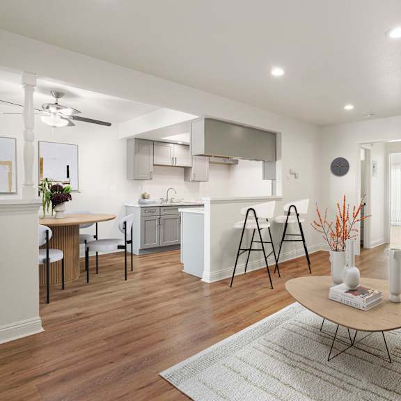 a modern living room with a kitchen in the background.