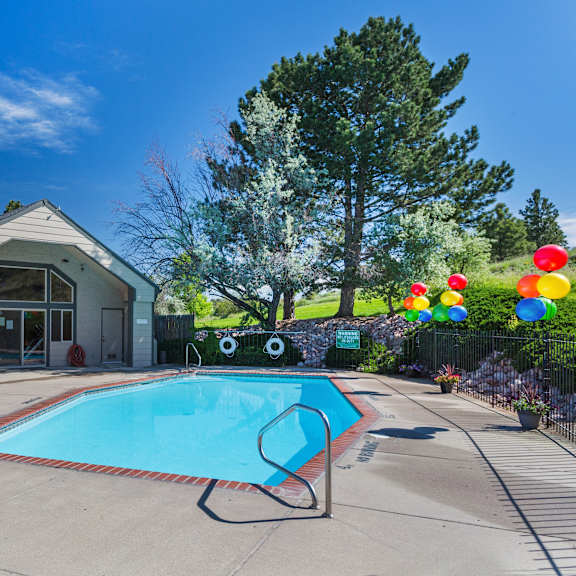a pool with a slide and a house in the background.