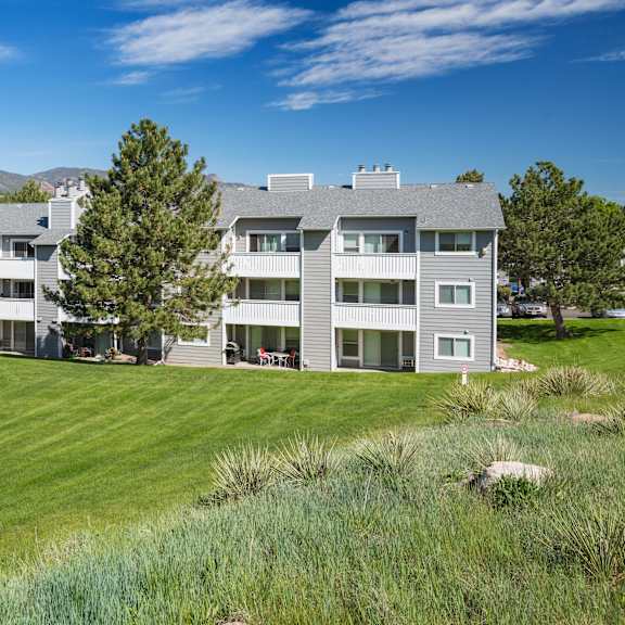 a large grey building with a green lawn in front.