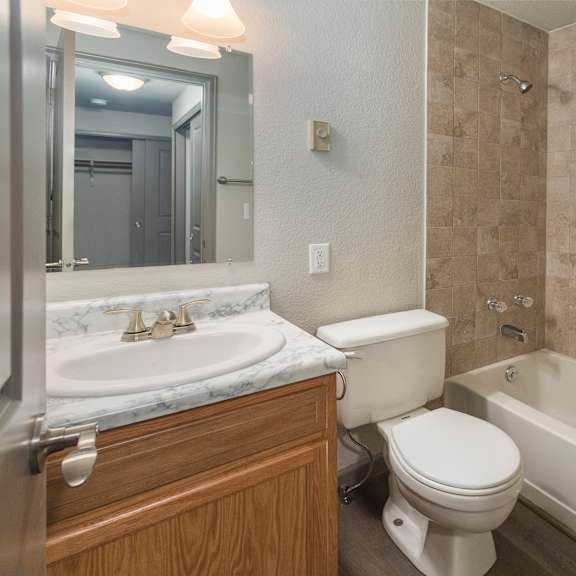 a bathroom with a toilet, sink, and bathtub.