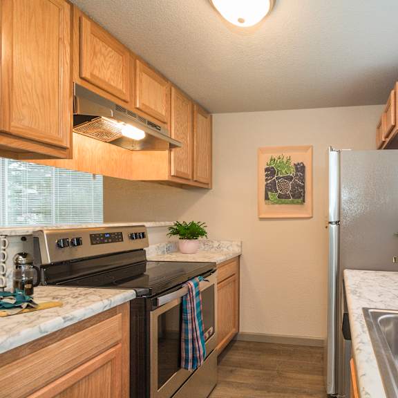 a kitchen with a refrigerator, sink, and stove.