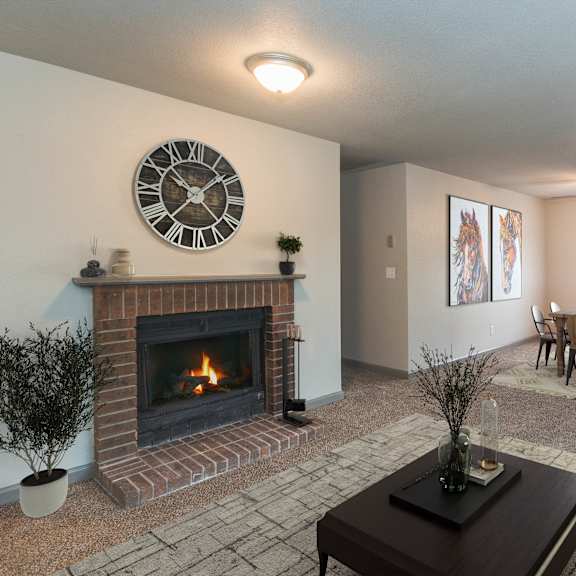 a living room with a fireplace and a clock on the wall.