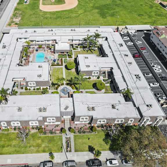 an aerial view of a large building with a pool in the middle.