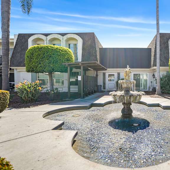 a house with a fountain in front of it.