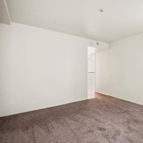 a room with a carpeted floor and a window with bars on it.