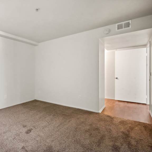 a room with a carpeted floor and a door on the right side.