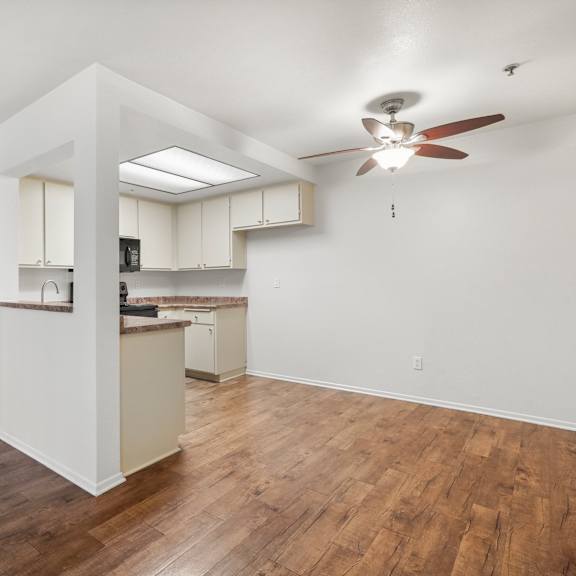 a kitchen with white cabinets and a wooden floor.