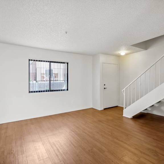 a room with a staircase and a window with bars.