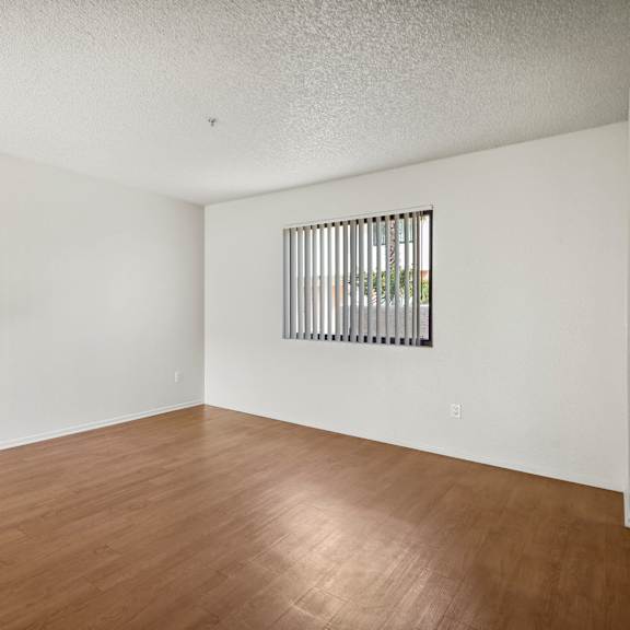 a room with wooden floors and a window with bars.