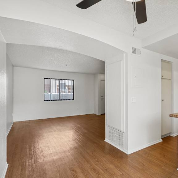 a room with a ceiling fan and a window with bars.