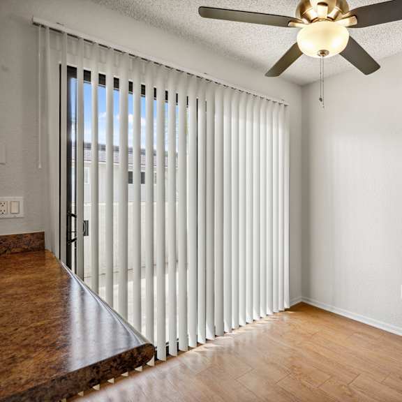 a room with a ceiling fan and a sliding door.