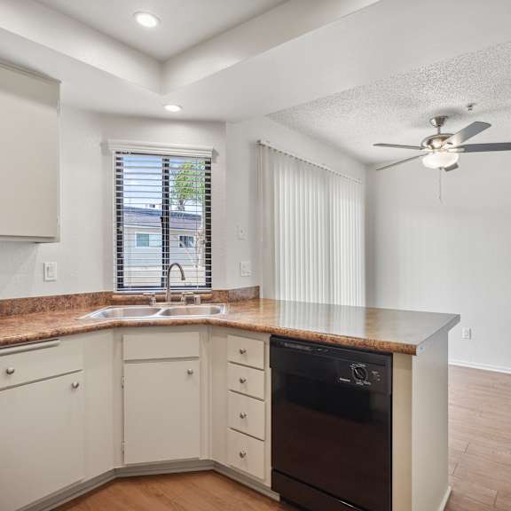 a kitchen with a brown countertop and a ceiling fan.