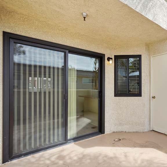 a white door with a black window is on the right side of a building.
