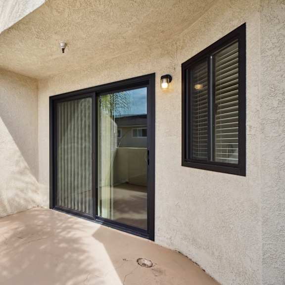 a modern house with a glass door and a wall made of concrete.
