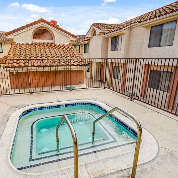 a small pool in a courtyard surrounded by houses.