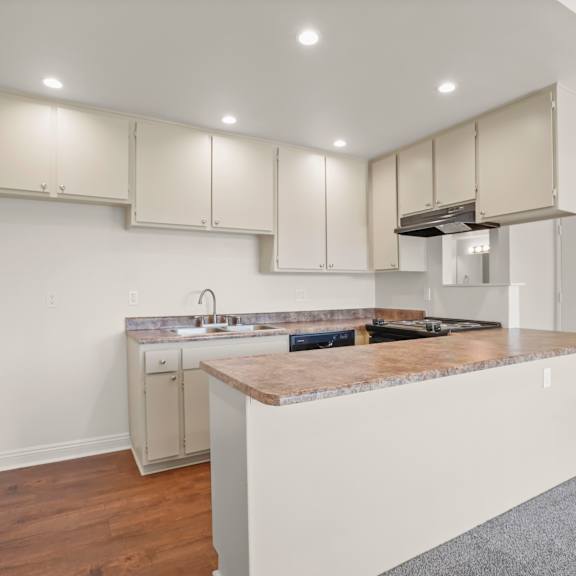 a kitchen with a marble countertop and white cabinets.