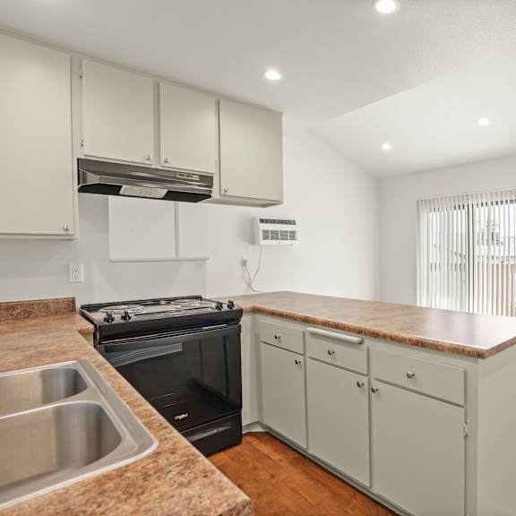 a kitchen with a stove, oven, and cabinets.