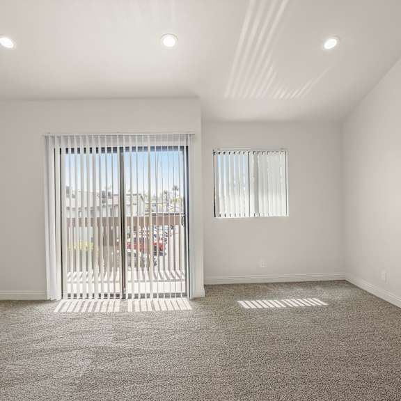 a room with a carpeted floor and a sliding glass door.