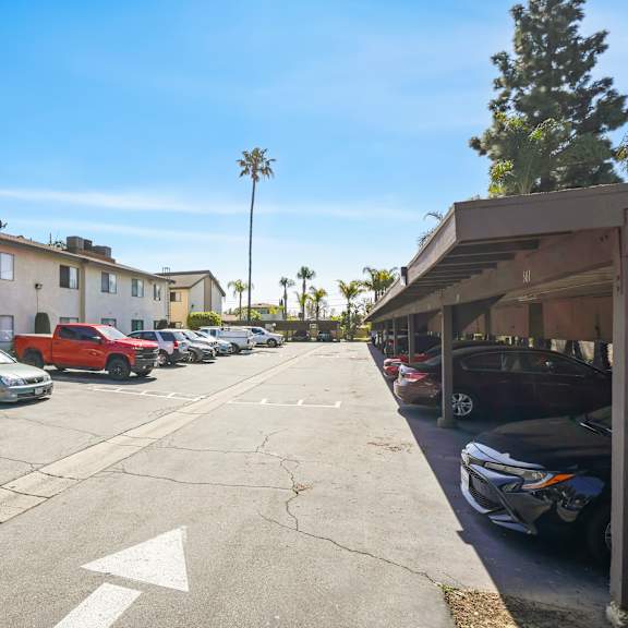 a parking lot with cars and directional arrows on the pavement.