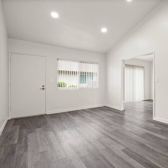 a room with a staircase and a window with blinds.