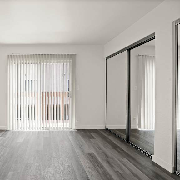 a room with a sliding glass door leading to a balcony.