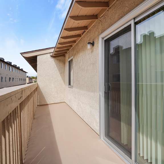 a balcony with a glass door and a window.