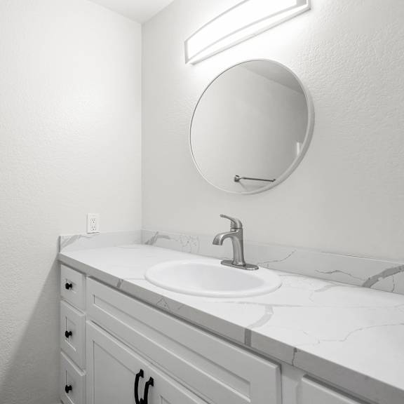 a bathroom with a sink and a mirror.