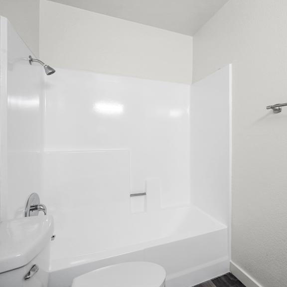 a white bathroom with a toilet, sink, and bathtub.
