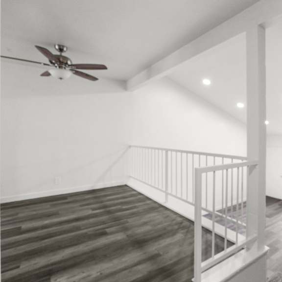 a room with a ceiling fan and a staircase.
