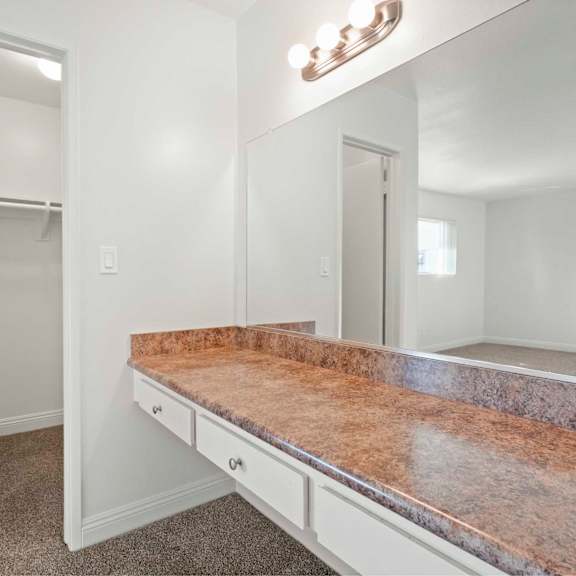 a bathroom with a marble countertop and a large mirror above it.