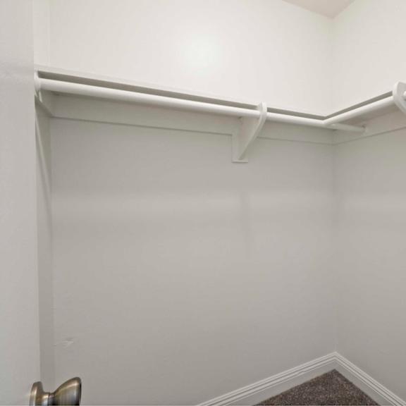 a white room with a corner and a carpeted floor.
