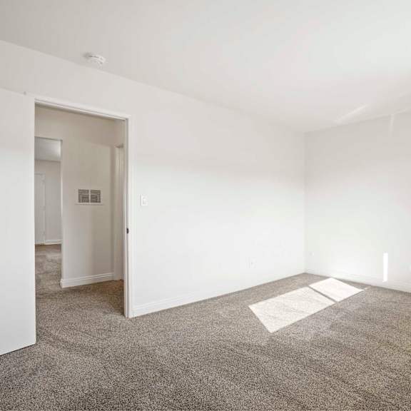 a room with a carpeted floor and a doorway leading to another room.