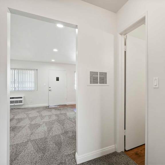 a white hallway with a door on the right.