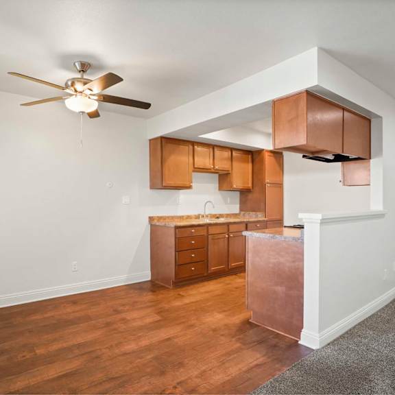 a kitchen with wooden cabinets and a ceiling fan.