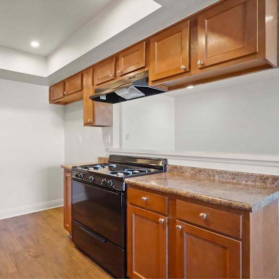a kitchen with wooden cabinets and a black stove top oven.