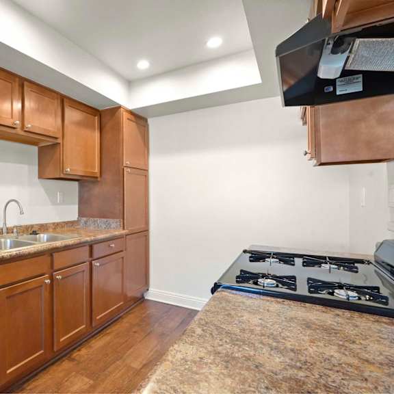 a kitchen with brown cabinets and a granite countertop.