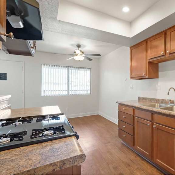 a kitchen with a stove top oven and wooden cabinets.
