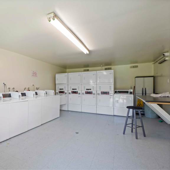 a clean, white industrial room with a row of machines on a long table.