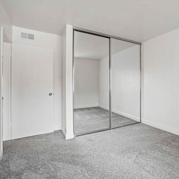 a room with a white door and a grey carpet.