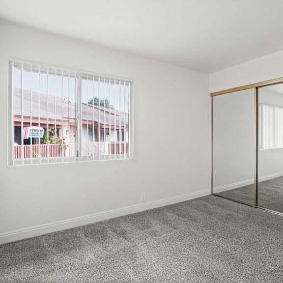 a room with a carpeted floor and a sliding glass door.