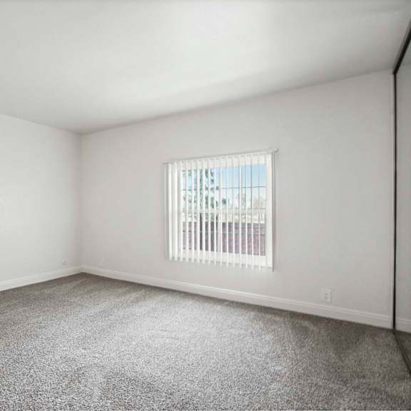 a room with a window and carpeted floor.