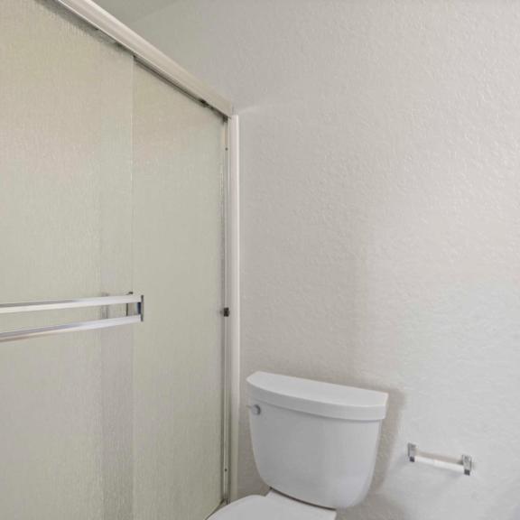 a white toilet sits in a bathroom next to a white door.