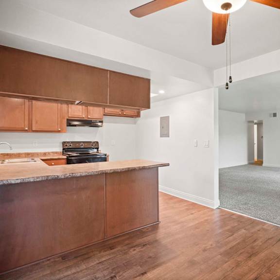 a kitchen with wooden cabinets and a ceiling fan.