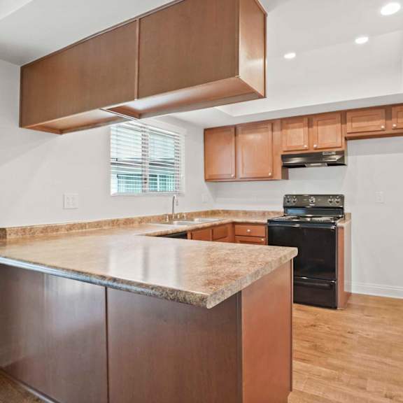 a kitchen with a granite countertop and wooden cabinets.