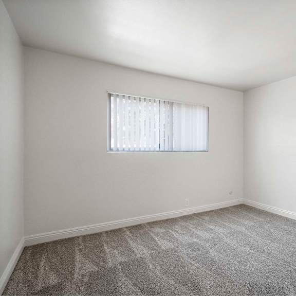 a room with a window covered by a white blind.