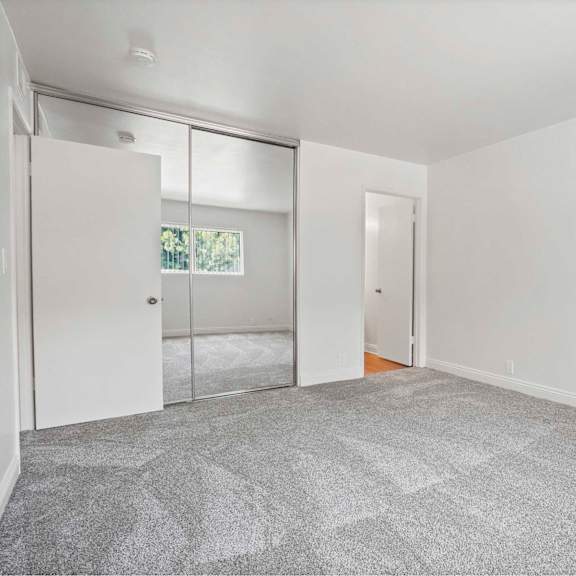 a room with a grey carpet and white walls.